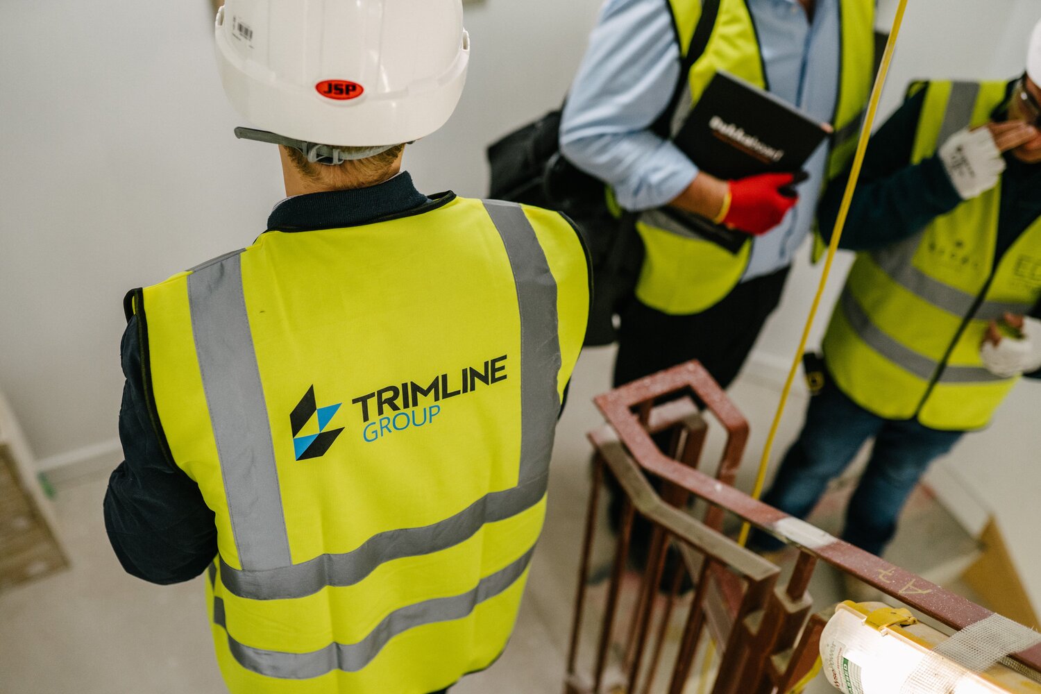 trimline team with contractors in stairwell wearing high visibility vests